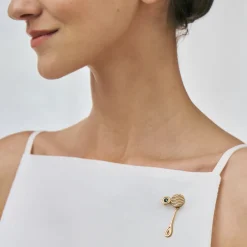 Pozłacany pin z niebieskim kryształem z kolekcji Holos