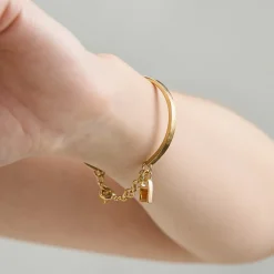 Sztywna, pozłacana bransoletka z dwoma bursztynami z kolekcji Baltica