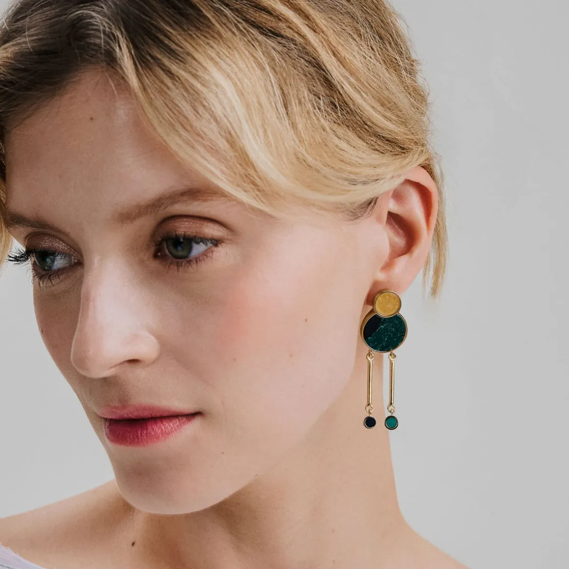 Złote, asymetryczne kolczyki z bursztynem z kolekcji Baltica