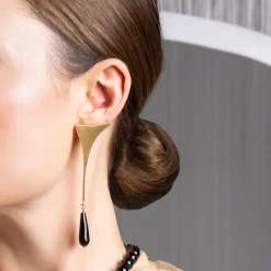Złote, asymetryczne kolczyki z perłą i onyksem z kolekcji Parer